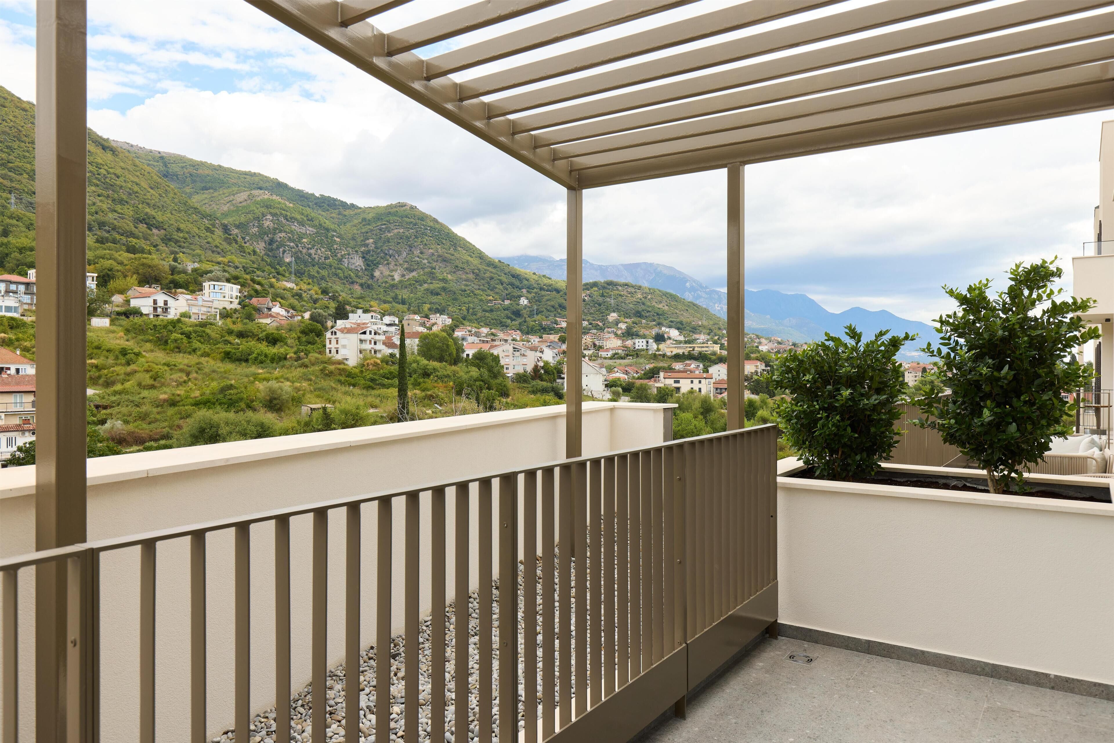 Un balcon avec vue sur la ville et les montagnes.