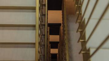 Una escalera moderna con barandilla metálica y pared en tonos neutros.