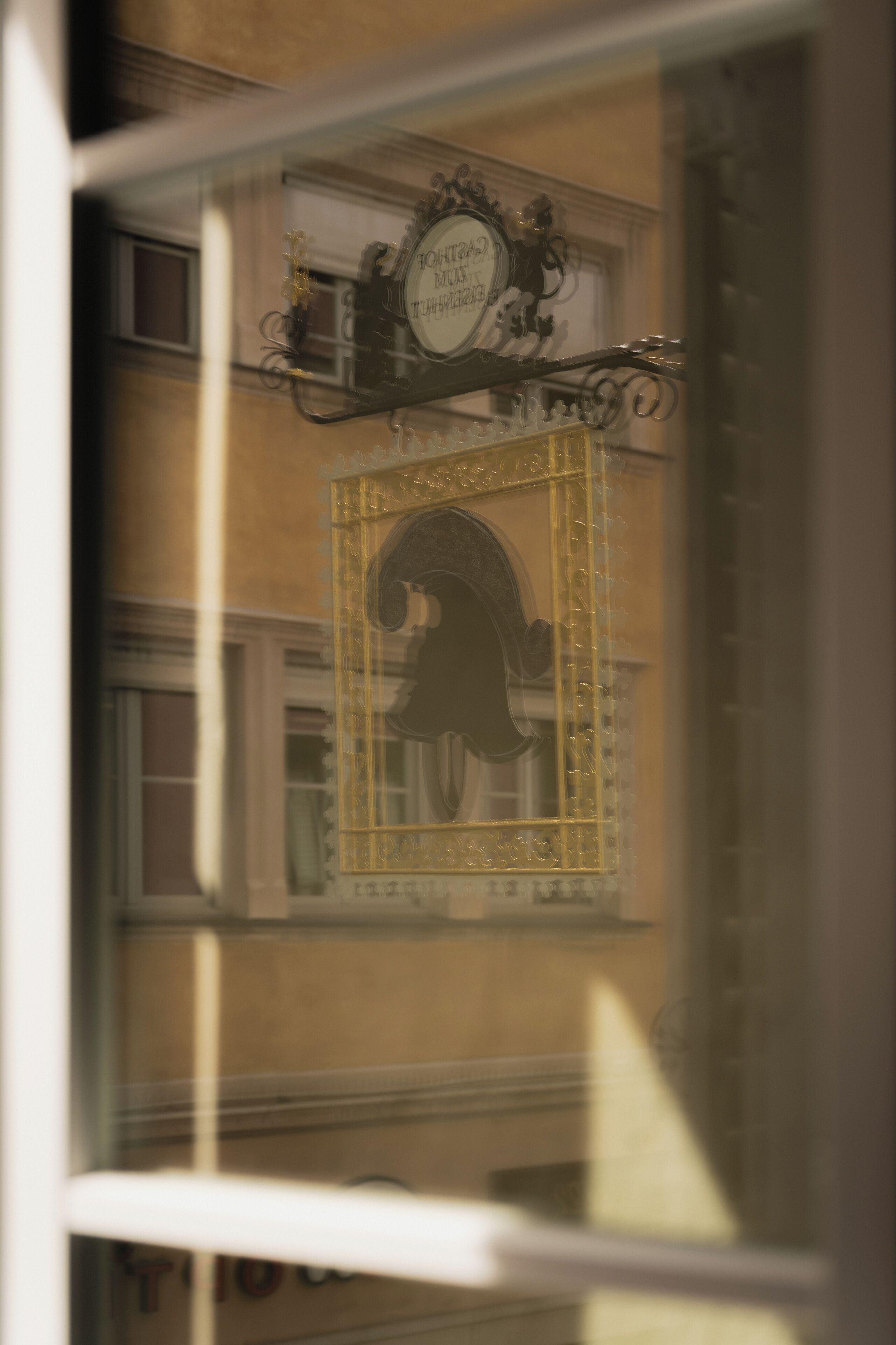 A building facade with a decorative sign featuring a silhouette of a person and ornate metalwork.