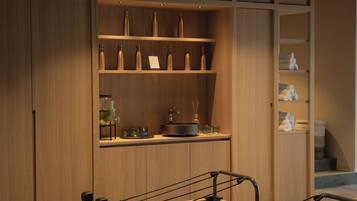 A Pilates studio with wooden walls, a mirrored wall, and a counter with bottles and towels.