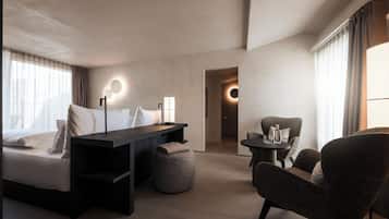 Una habitación de hotel moderna con una cama, un escritorio, una silla y una pequeña mesa.