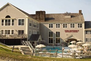A two-story building with a swimming pool and outdoor seating area. - Mountain View Suite at Jiminy Peak - Ski On Off - Near Elevator, Pool, and Lobby (Hancock)