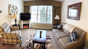 Een gezellige woonkamer met een open haard, een televisie en twee banken.