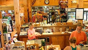 L'intérieur d'un magasin animé, avec des murs en bois et des étagères remplies de divers articles.
