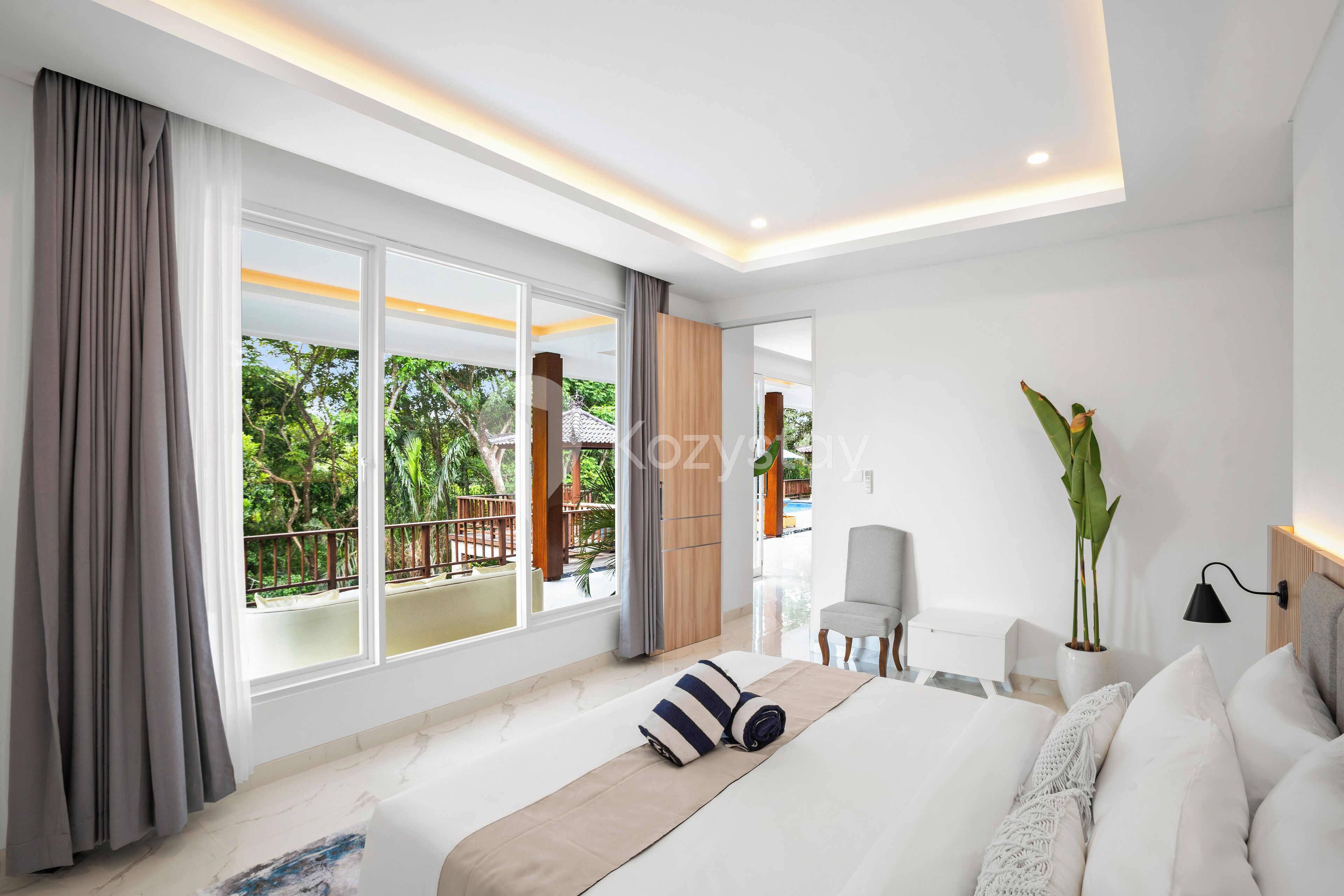 Habitación de hotel moderna con una cama grande, vistas al exterior y un balcón.