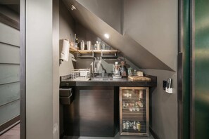 Eine kompakte Küchenzeile mit Kaffeemaschine, Mixer und kleinem Kühlschrank.