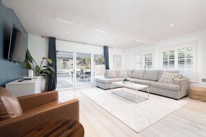 A modern living room with a sofa, coffee table, and TV.