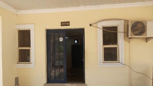 A reception area with a closed door, a sign above it, and an air conditioning unit mounted on the wall. - De - Calmcity Guest House  (Ilorin)