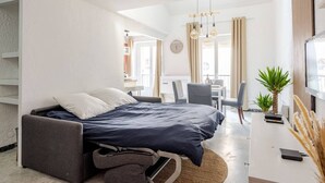 Ein modernes Hotelzimmer mit Bett, Schreibtisch und Fernseher.