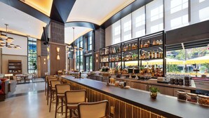 Eine moderne Bar mit einer langen Theke, verschiedenen Sitzmöglichkeiten und einer gut sortierten Spirituosenregal.
