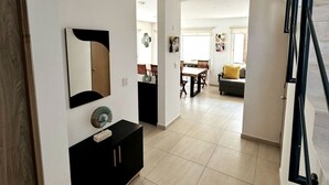 A modern interior with a dining area, a sofa, and a staircase. - Casa con alberca propia-Almarena (Mazatlán)