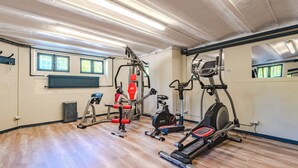 Une salle de sport équipée de matériel d’exercice, avec un radiateur et une fenêtre.