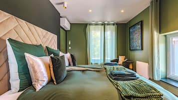 Een hotelkamer met een groot bed, een hoofdeinde, een raam met gordijnen en een schilderij aan de muur.
