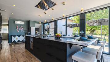 A modern kitchen with a large island, bar seating, and a view of the outdoors.