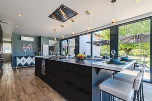 A modern kitchen with a large island, bar seating, and a view of the outdoors.