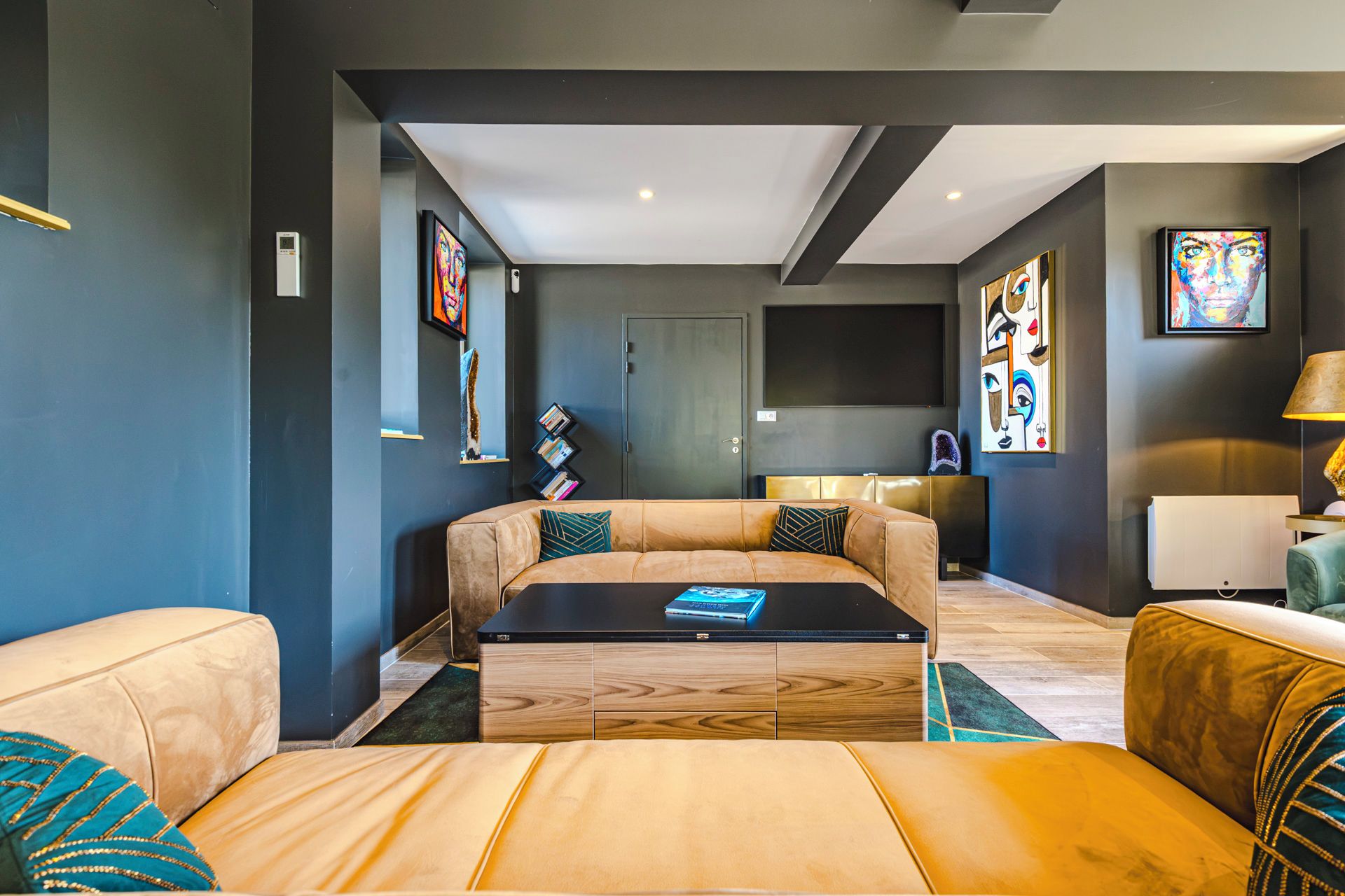 Een moderne woonkamer met een bank, salontafel en kunst aan de wanden.