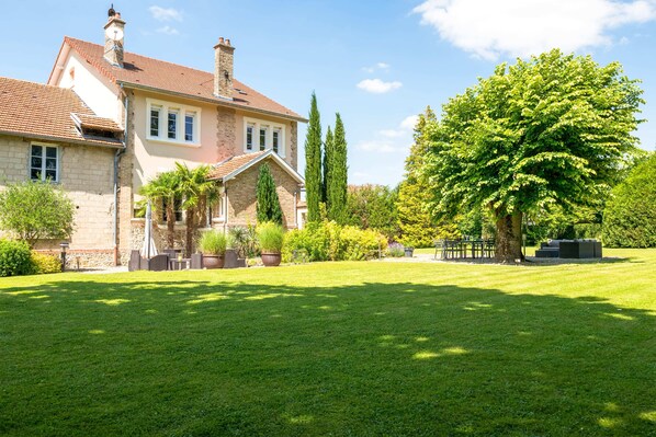 A large house with a well-maintained lawn and a variety of trees and shrubs. - L'Artbanne - The Hestia house (Saint-Hilaire-le-Petit)