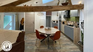 Eine moderne Küche mit Essbereich, ausgestattet mit einem Oberlicht, Holzbalken und Blick ins Freie.