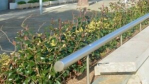 A paved walkway with a metal railing on one side and a landscaped area with plants on the other. - 1-Bed Apt in Platja d'Aro with Terrace & Parking (Platja d'Aro)