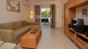 A modern living room with a sofa, coffee table, TV stand, and artwork on the walls. - Apartment in Platja d'Aro near the beach with air conditioning and WiFi (Platja d'Aro)
