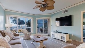 A living room with a sofa, a coffee table, a TV, and a ceiling fan. - Oceanfront Palmetto Dunes Villa w/ Balcony, King Suite & Stunning Views (Hilton Head Island)
