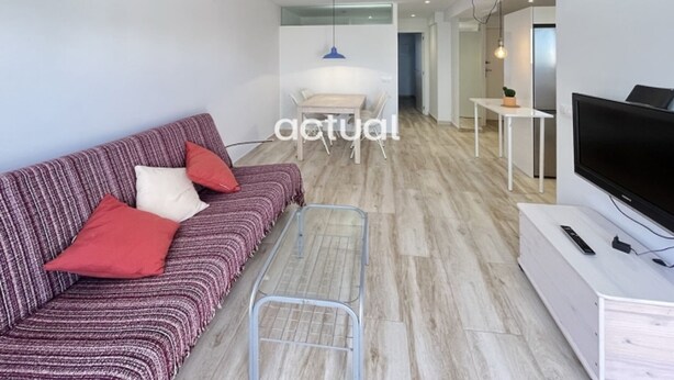 Een moderne woonkamer met een bank, een salontafel en een televisie.