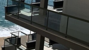 A multi-story building with balconies overlooking the ocean. - Seaside apartment with terrace, optional AC, parking, and WIFI (Platja d'Aro)