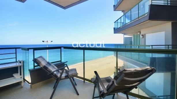 A balcony with two lounge chairs and a view of the beach. - 3-bedroom beachfront apartment with terrace in Platja d'Aro (Platja d'Aro)