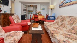 A living room with red sofas, a wooden coffee table, and a painting on the wall. - 2-bedroom apartment with terrace, sea view and parking in Platja d'Aro (Platja d'Aro)