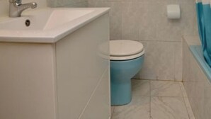 Et badeværelse med en hvid vask, toilet og badekar.
