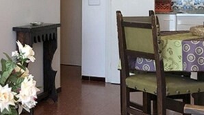 A dining area with a wooden chair, a table, and a vase of flowers. - Beachfront apartment: 1 bedroom, terrace, parking (Platja d'Aro)