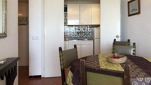 A compact kitchen with white cabinets and blue and white patterned backsplash. - Beachfront apartment: 1 bedroom, terrace, parking (Platja d'Aro)