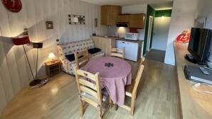 A compact living space with a dining area, kitchenette, and a television. - Cozy studio 4 ppl at slopes' foot (Laveissière)