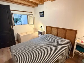 A bedroom with a bed, a bedside table, a nightstand, a window, and a door. - Charming village house in Argelès-sur-Mer close to amenities (Argelès-sur-Mer)