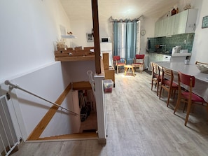 Una cocina con comedor, muebles de madera y una escalera.