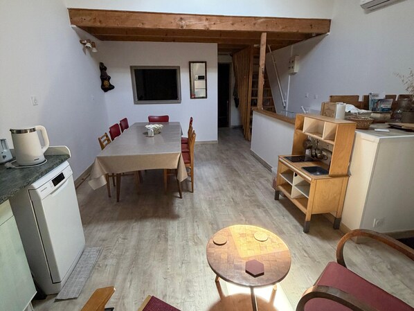 Una cocina compacta con una mesa de comedor, sillas, una mesita redonda y un armario de madera.