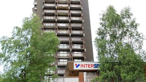 A high-rise building with multiple balconies and a sign for 'INTERSPACES'. - Ski-in/Ski-out Studio, 2 guests, Le Corbier Residence (Le Corbier)