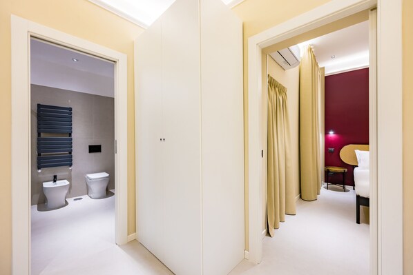 A modern bathroom with a toilet, bidet, and towel rack.