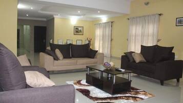 Habitación Deluxe, balcón, vista a la ciudad | Área de sala de estar