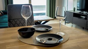A dining table with two wine glasses, a black bowl, and a black plate. - RentPlanet - Apartament Czysta (Wroclaw)