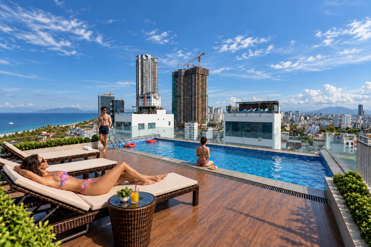 A rooftop pool area with lounge chairs, a swimming pool, and a view of the cityscape and ocean.
