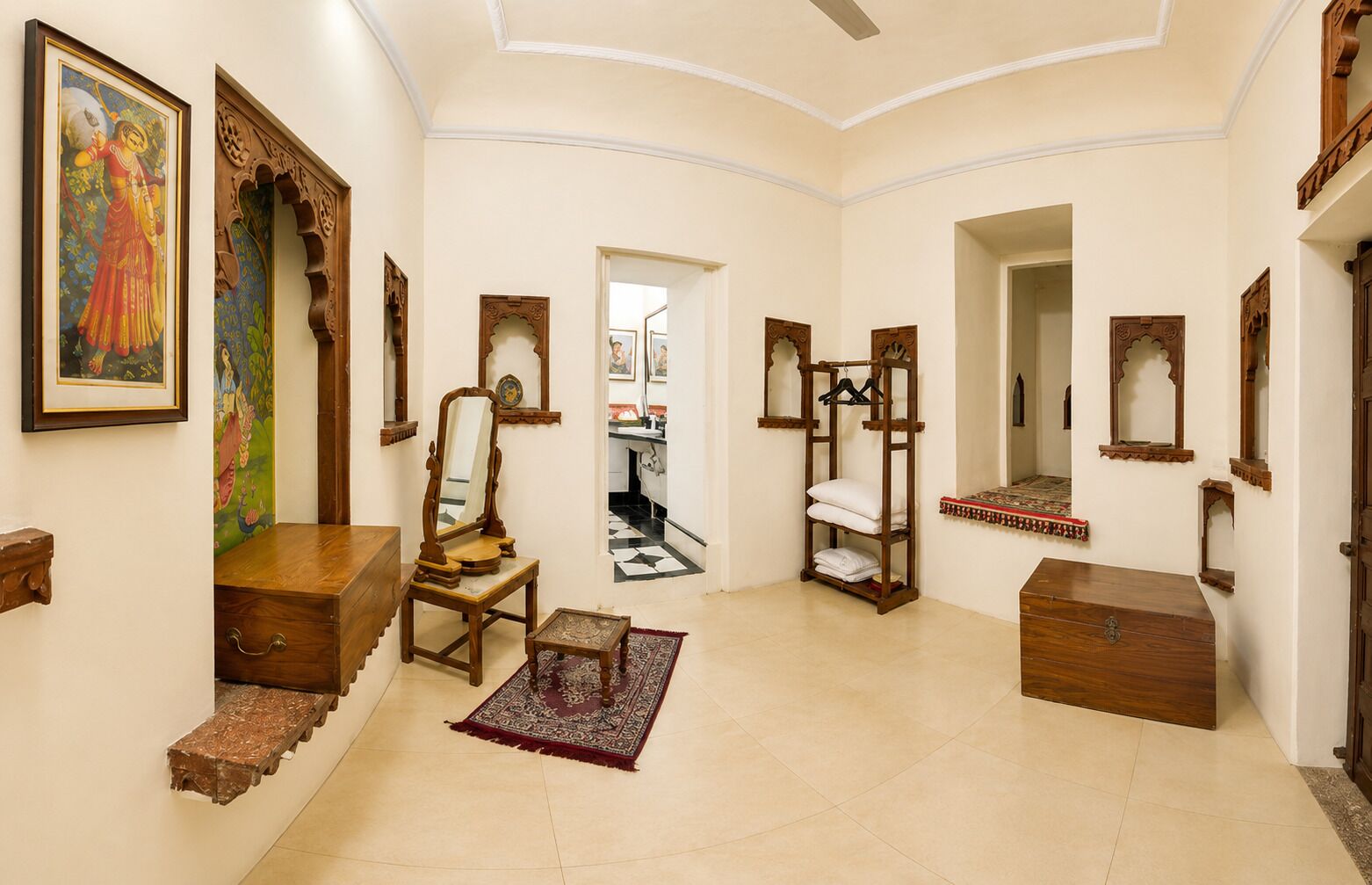 A hallway with wooden furniture, a mirror, and a painting.