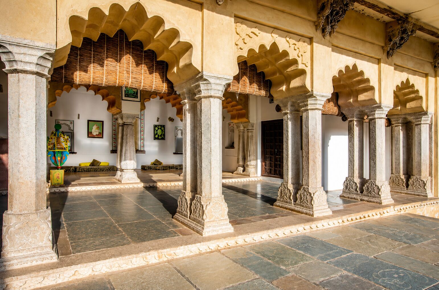 An interior courtyard with arches, columns, and a tiled floor.
