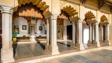 An interior courtyard with arches, columns, and a tiled floor.