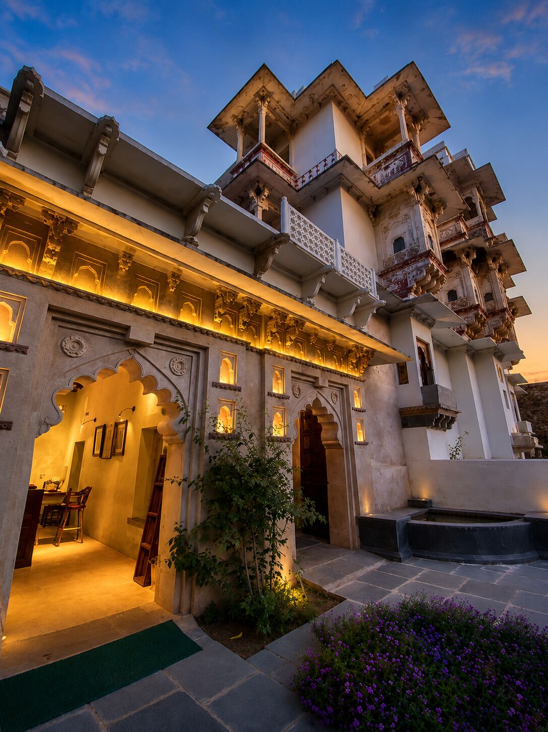 A traditional building with multiple balconies, arched doorways, and a courtyard with a water feature.