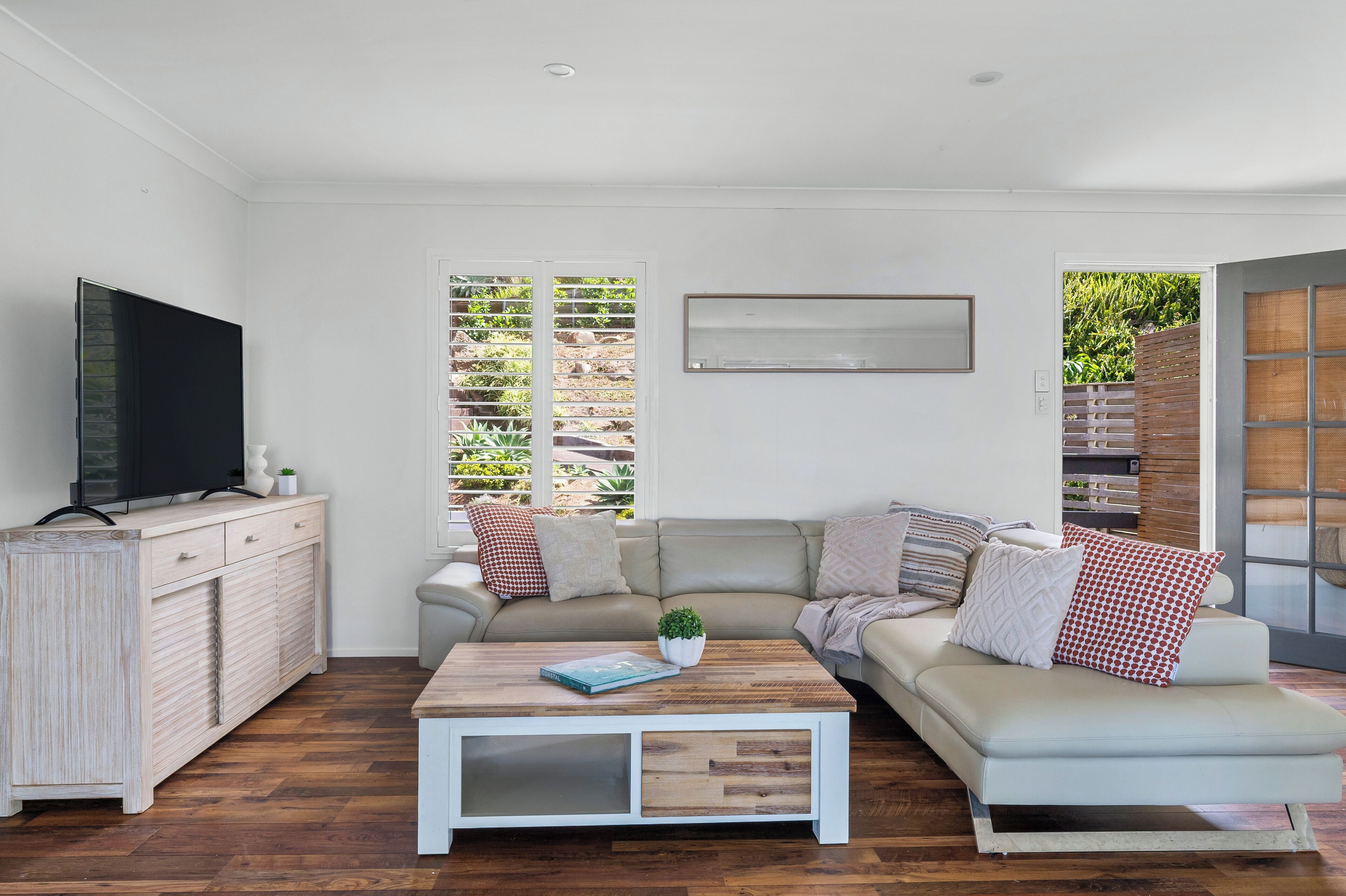 A modern living room with a sofa, coffee table, and TV.