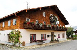 A traditional wooden building with flower boxes and a bench outside. - Gasthof Zur Alten Post (Hinterschmiding)
