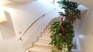 A spiral staircase with beige steps, a handrail, and a potted plant on the landing. - Spacious Penthouse-5 Rooms apartment in Best location  (Jerusalem)