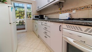 Una cocina equipada con lavadora, microondas y estufa.