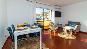 Ein modernes Wohnzimmer mit Essbereich, einer Couch und einem Fernseher.